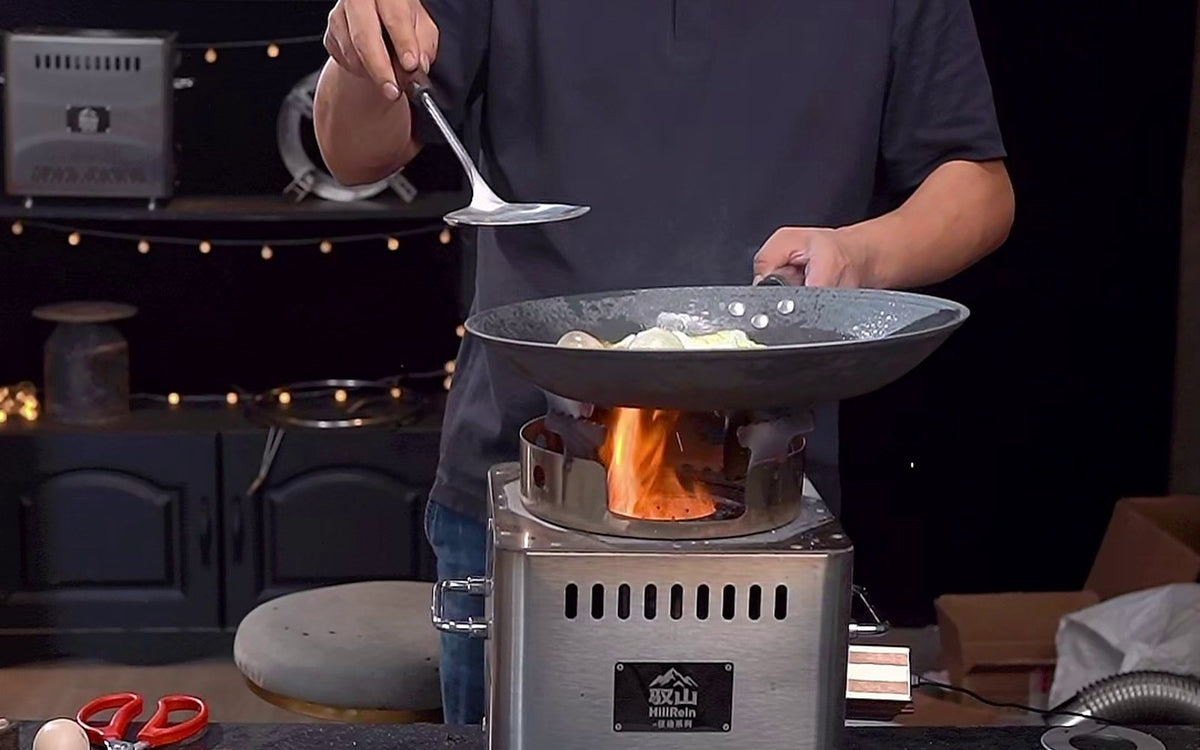 Hillrein Zhengtu wood stove for wok cooking with vegetables in a wok, a cook holding a spatula, and flame below the pan