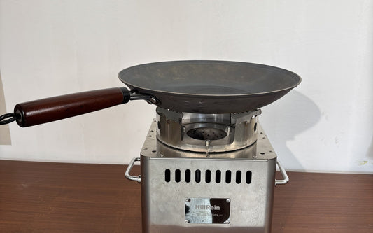 Hillrein Zhengtu small wood cooking stove with an empty shallow pan and wooden handle, illustrating the pan shape to check against a spatula