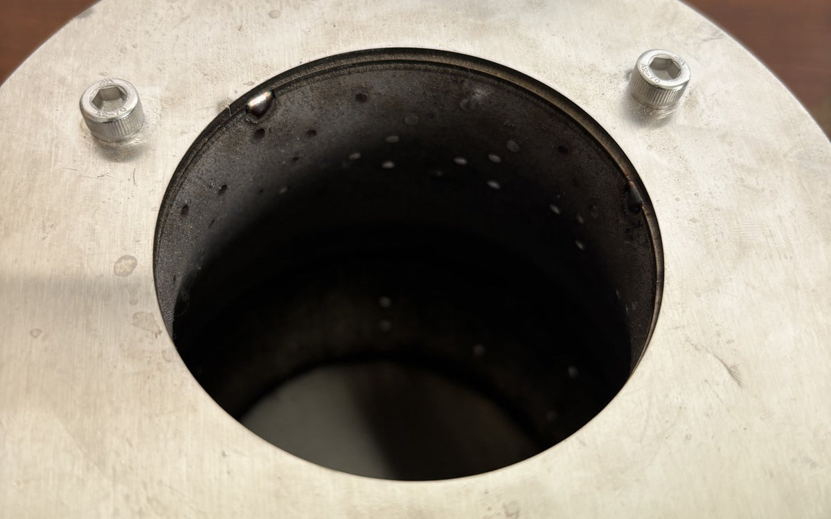 Hillrein Zhengtu 304 stainless steel wood stove inner chamber viewed from above, with circular opening, rim bolts and rows of small wall openings