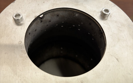 Hillrein Zhengtu 304 stainless steel wood stove inner chamber viewed from above, with circular opening, rim bolts and rows of small wall openings