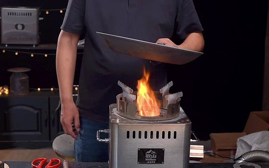 Hillrein portable wood burning cooking stove image showing the Zhengtu during real pan cooking, with the wok lifted briefly while the last short dry stick catches underneath
