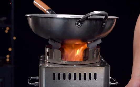 Hillrein Zhengtu wood stove for wok cooking with a two-handled wok resting on the pot support and a spatula inside
