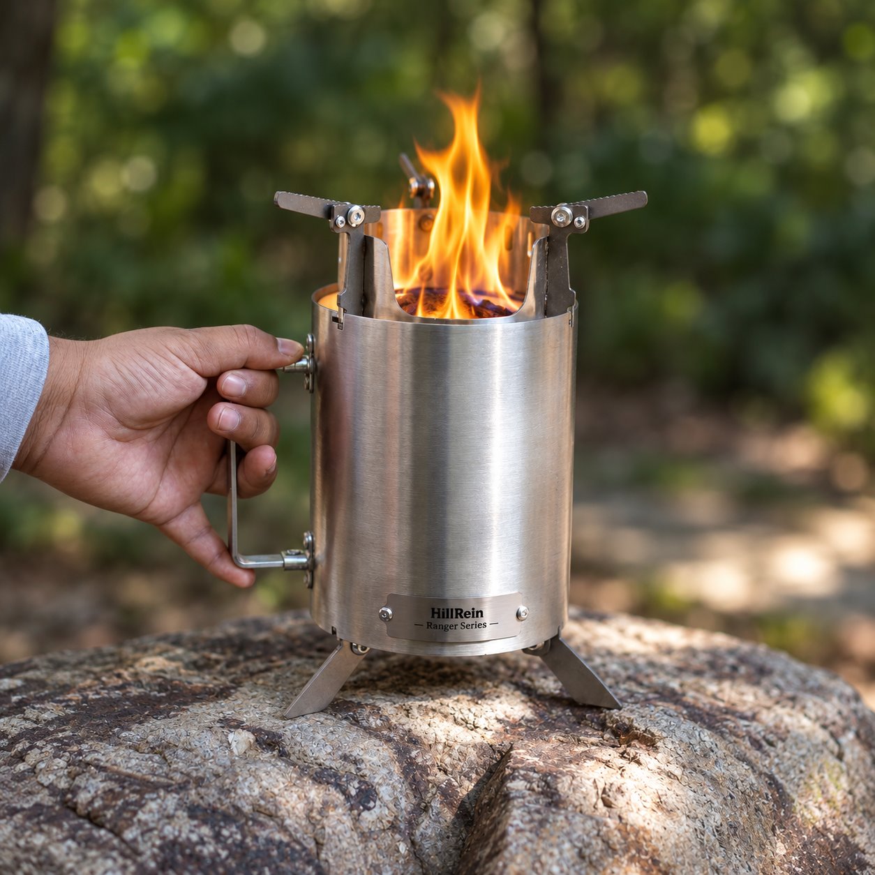 Compact Hillrein Ranger stove held by its handle with a wood flame